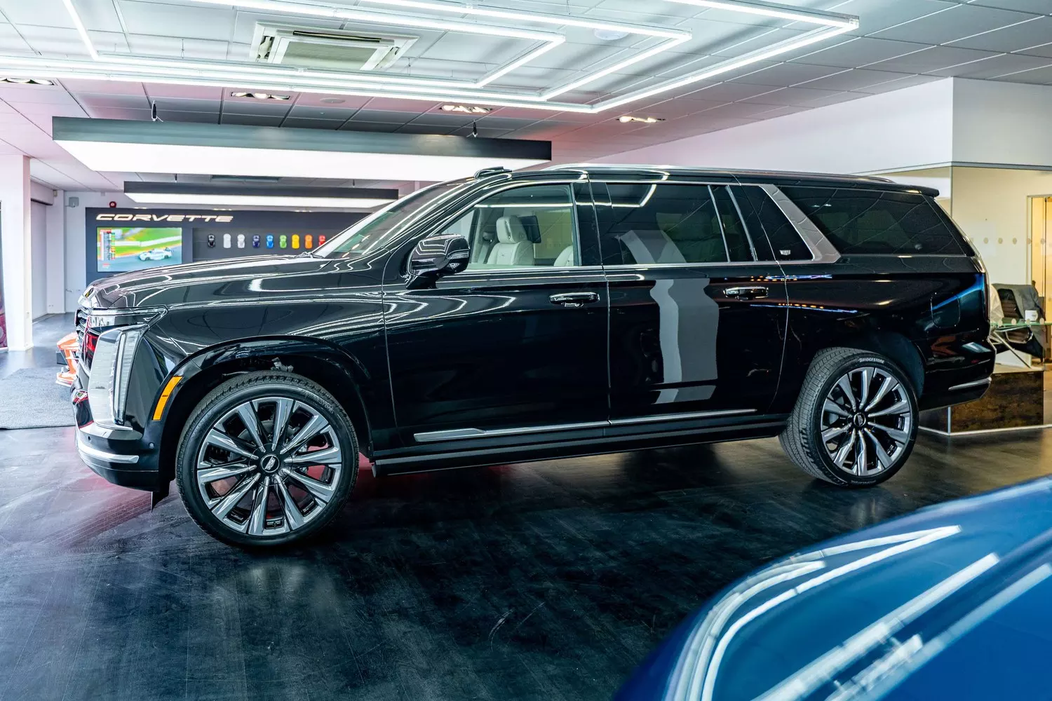 Side profile of the Cadillac Escalade in the showroom
