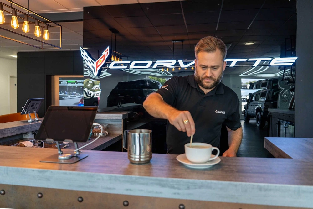 Grange colleague preparing coffee behind the showroom bar