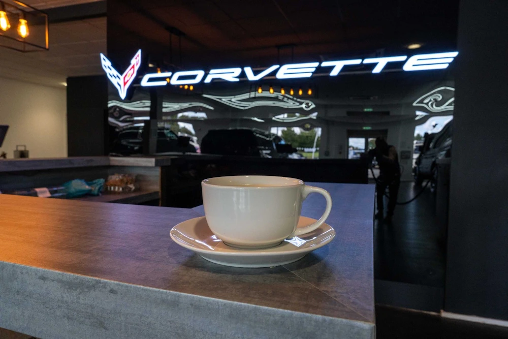 Coffee cup on the guest bar with Corvette branding behind it