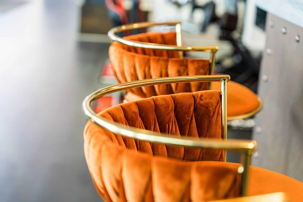 Orange bar stools with gold-coloured frames at Grange Birmingham