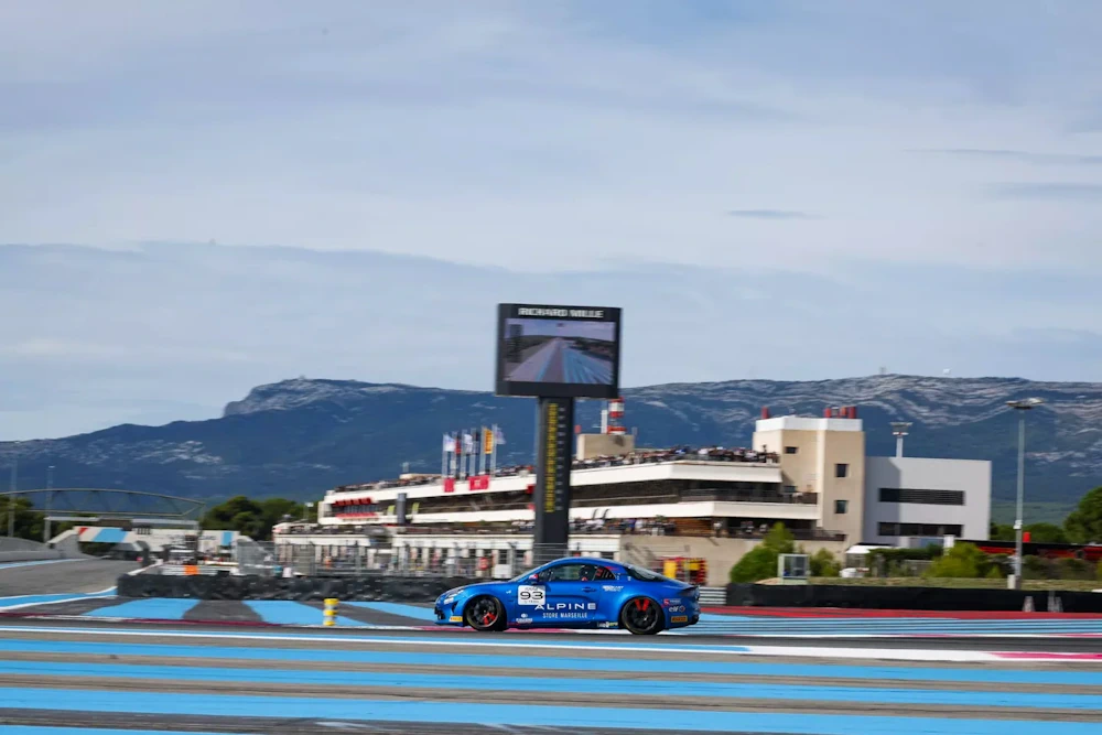 Alpine race car on the blue-striped Circuit Paul Ricard track