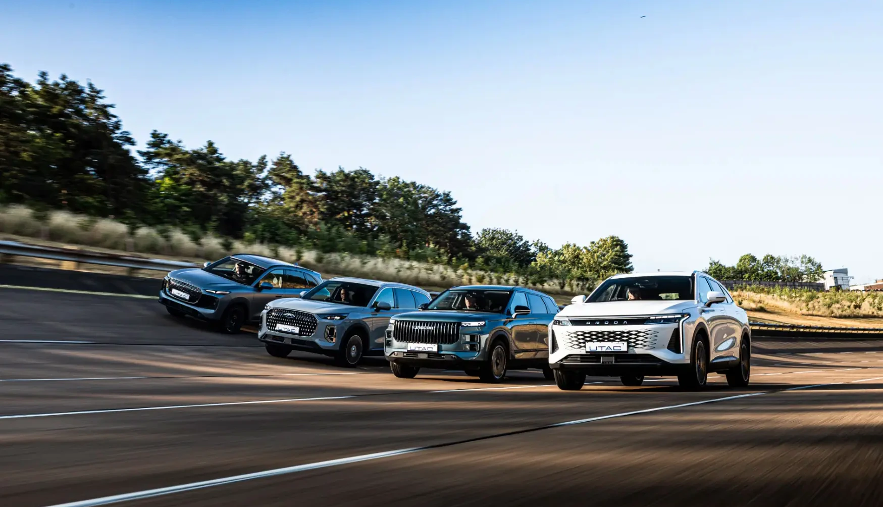 Chery, OMODA and JAECOO SUVs being driven together on a banked test track at UTAC Millbrook