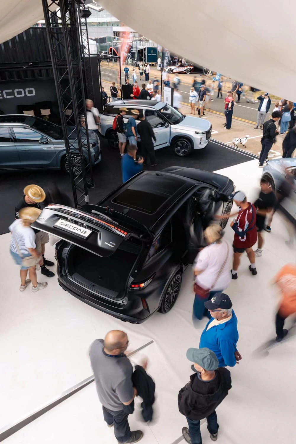 Visitors viewing an OMODA 9 at an OMODA and JAECOO display