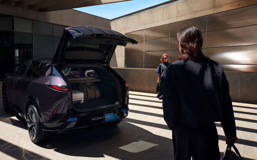 Mazda CX-6e with its tailgate open and luggage in the boot