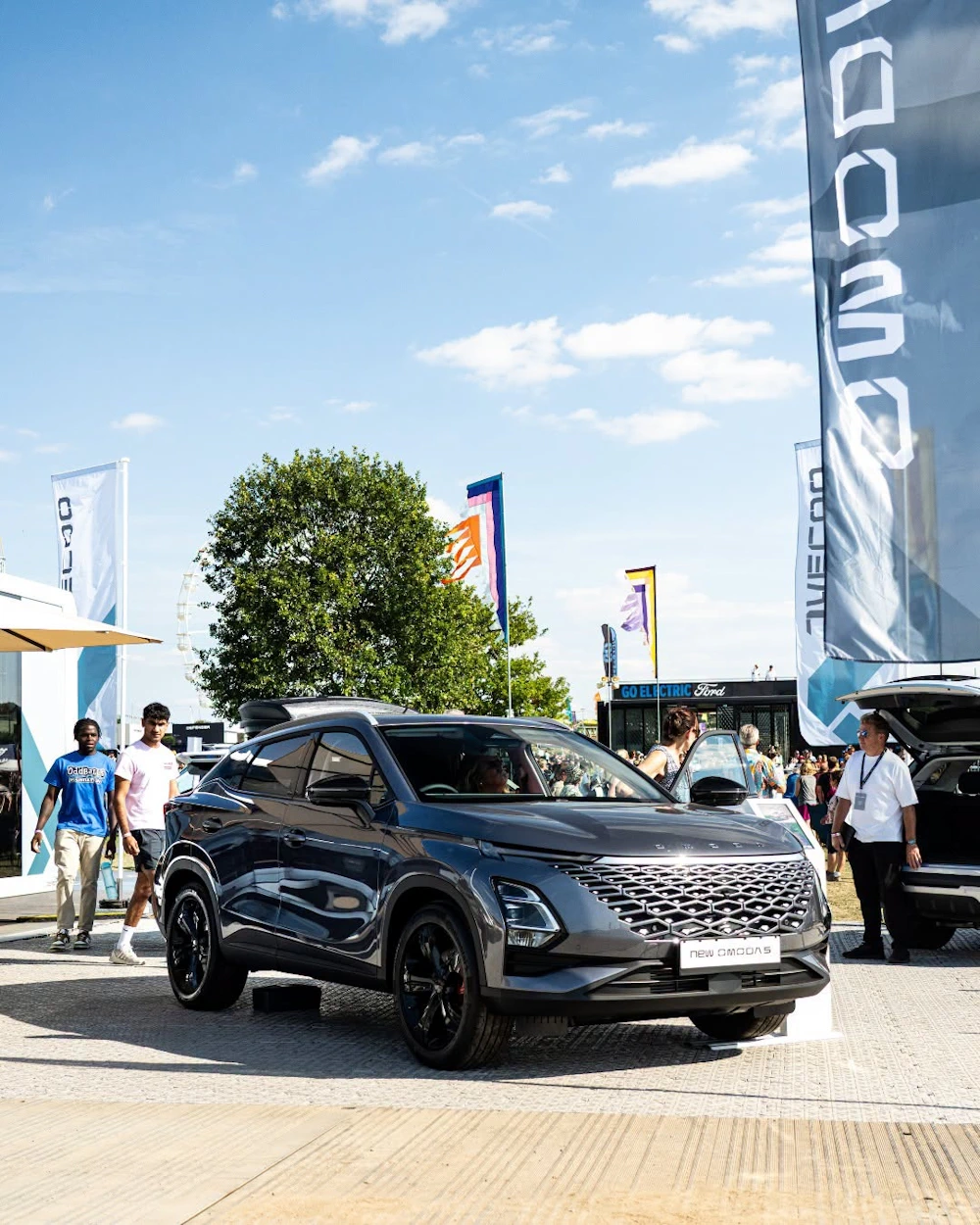 Visitors viewing a grey OMODA 5 at an outdoor event