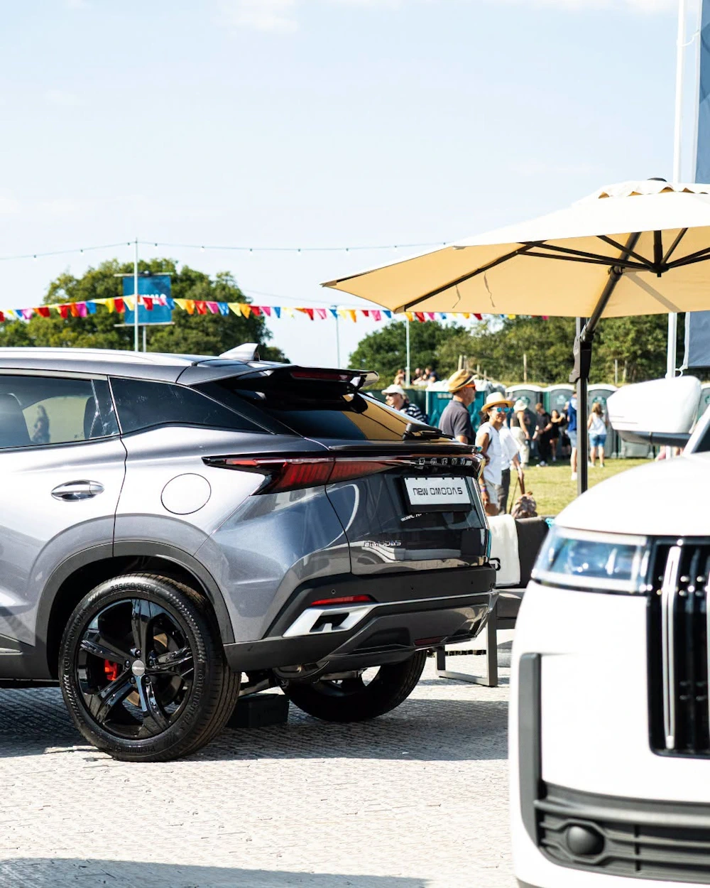 Rear view of an OMODA 5 with a JAECOO SUV alongside at an outdoor display