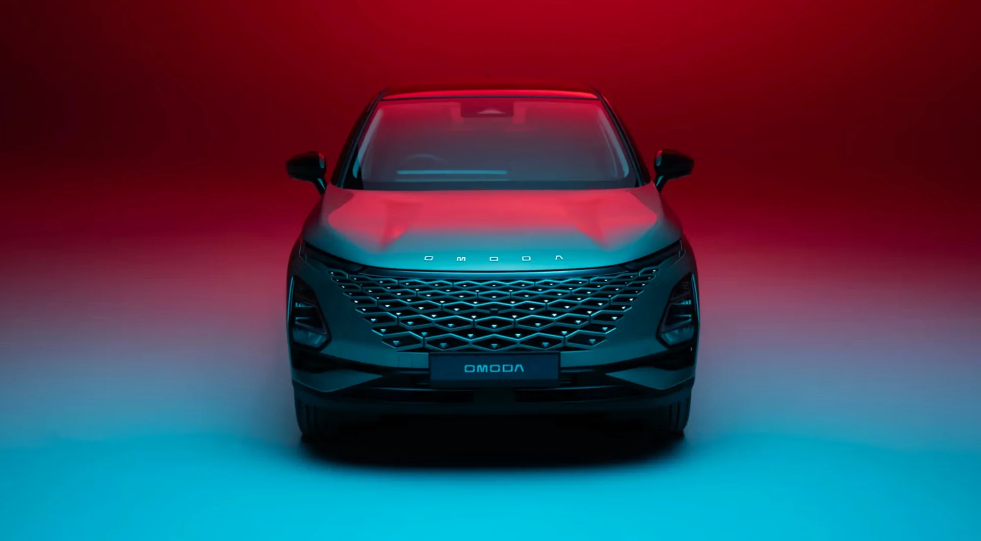 OMODA 5 compact SUV driving through a city at dusk
