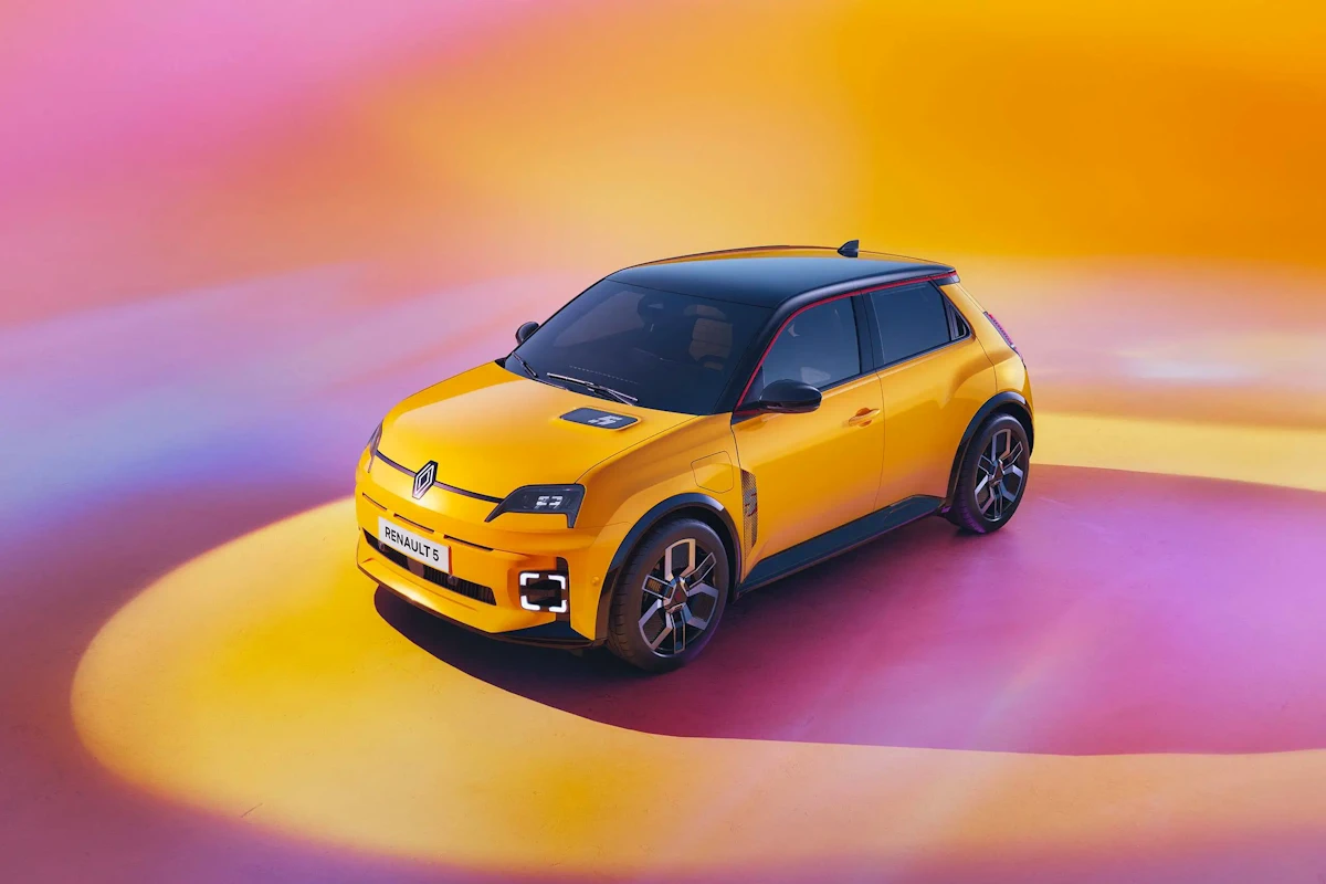 Yellow Renault 5 E-Tech electric parked against a colourful background