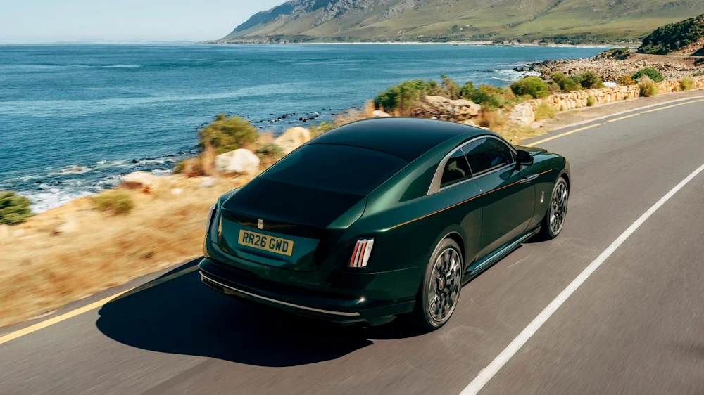 Rolls-Royce Spectre Series II driving beside a coastal landscape