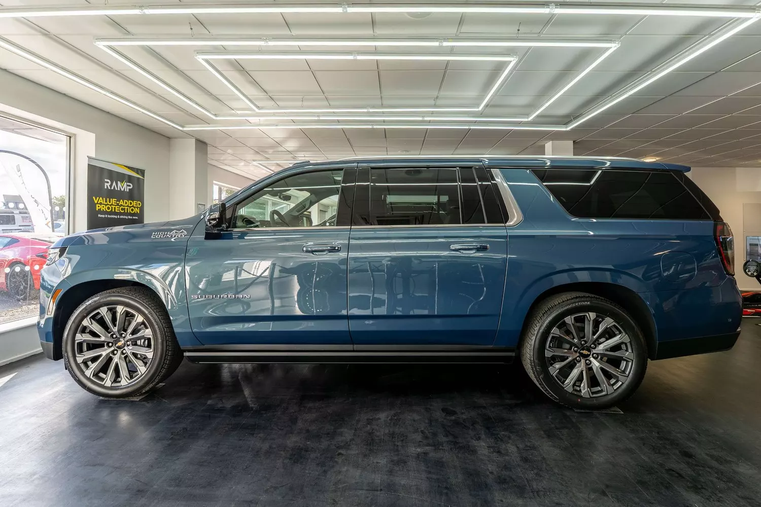 Full side profile of the blue Chevrolet Suburban